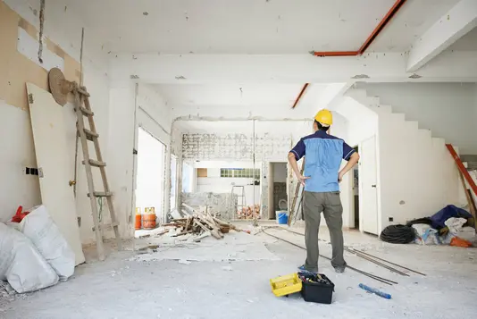 hausbau-haus-bauen-eigenleistung-handwerker-rohbau-04 Handwerker betrachtet den Rohbau von innen.