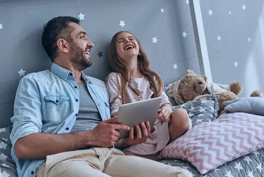 Haus-Vater-Tochter-Wohnen-Serie-4-15 Vater und Tochter schauen auf ein Tablet und lachen